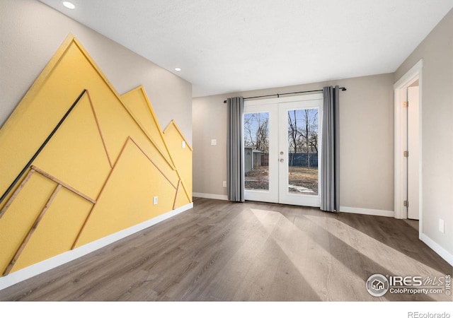 spare room featuring hardwood / wood-style flooring and french doors