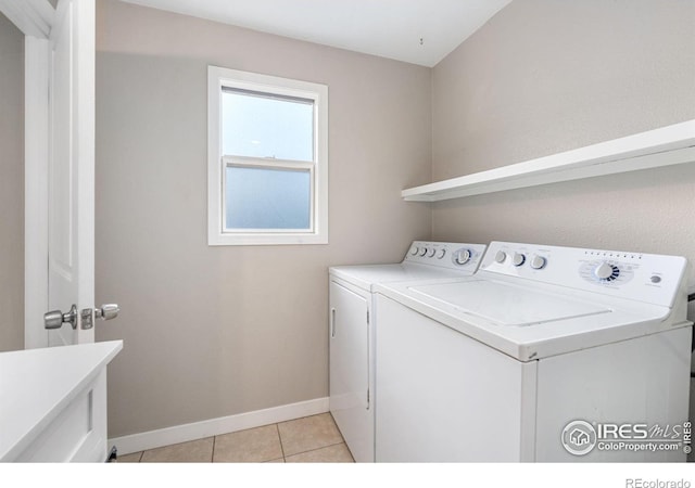 laundry area with washer and clothes dryer and light tile patterned flooring