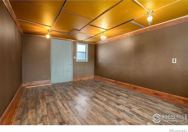 unfurnished room with ornamental molding and wood-type flooring