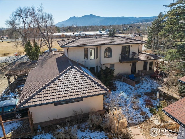 rear view of property featuring a balcony and a mountain view