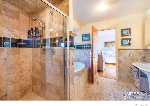 bathroom with separate shower and tub and tile walls