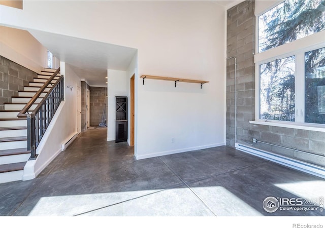 unfurnished living room featuring a baseboard heating unit