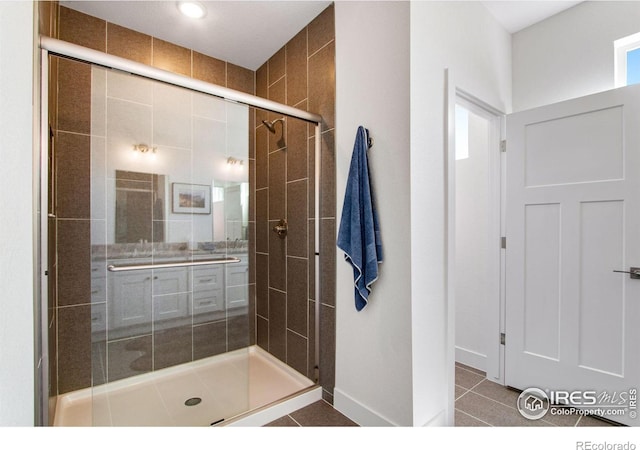 bathroom featuring a shower with shower door and tile patterned floors