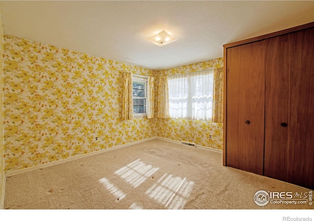 unfurnished bedroom featuring carpet and a closet