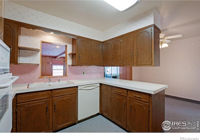 kitchen with kitchen peninsula, sink, decorative backsplash, ceiling fan, and white dishwasher