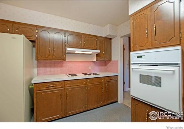 kitchen featuring white appliances and backsplash