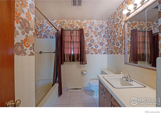 full bathroom with tile walls, vanity, shower / bath combination with curtain, tile patterned floors, and toilet