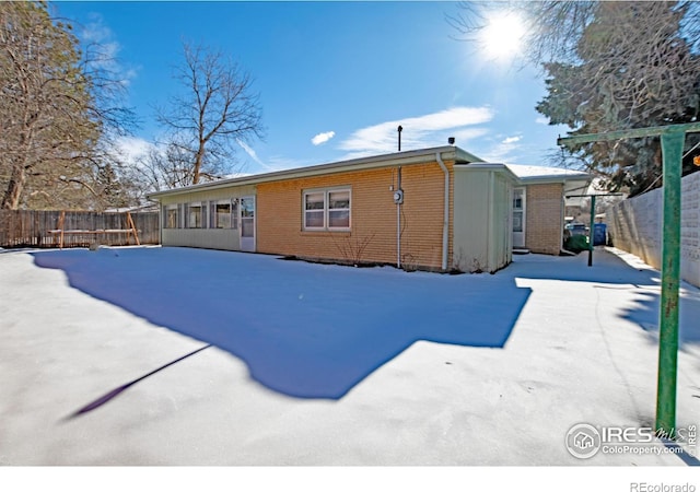 view of snow covered rear of property