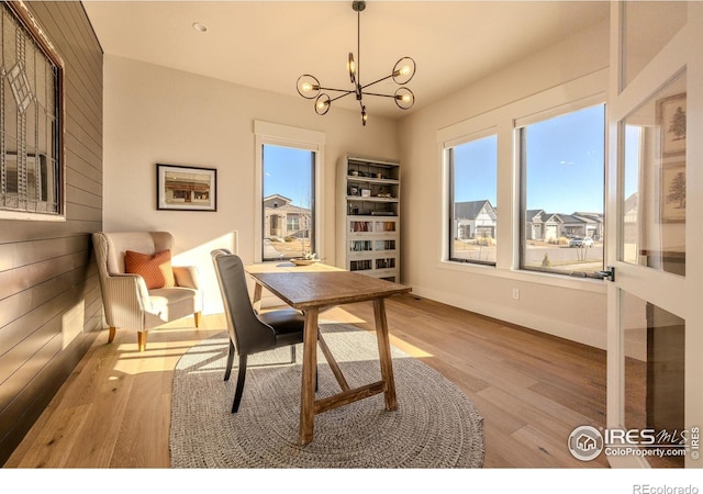 office area with light hardwood / wood-style floors and an inviting chandelier