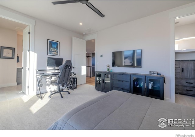 bedroom with ceiling fan, light carpet, and ensuite bath