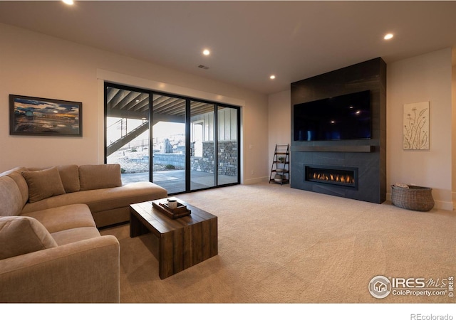 living room with light carpet and a tile fireplace