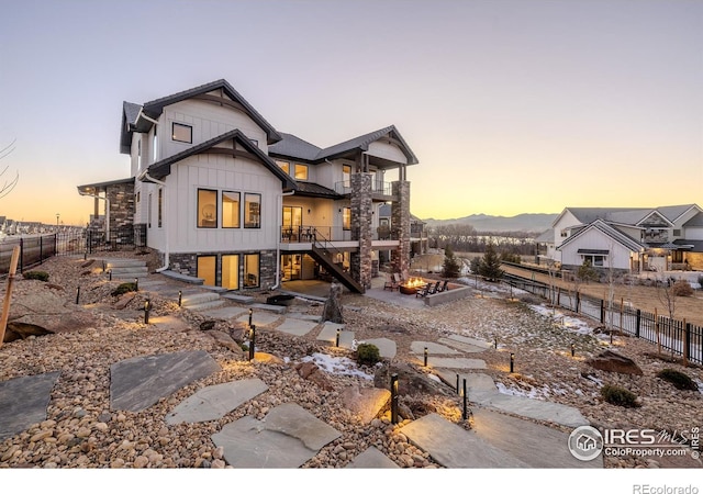 back house at dusk featuring a balcony