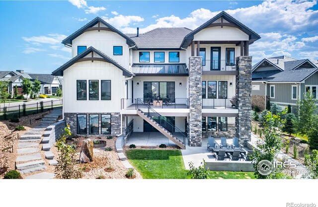 2294 Stonebrae Ct, Berthoud, CO 80513 - rear view of house featuring stairway, a balcony, a standing seam roof, stone siding, and a patio area