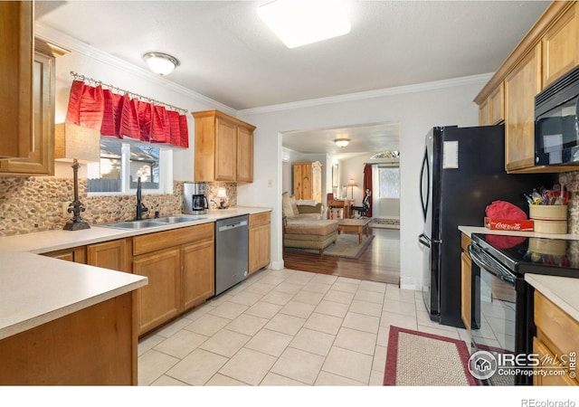 kitchen with sink, decorative backsplash, ornamental molding, and black appliances