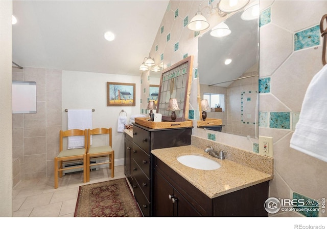 bathroom with vaulted ceiling, vanity, and tile patterned flooring