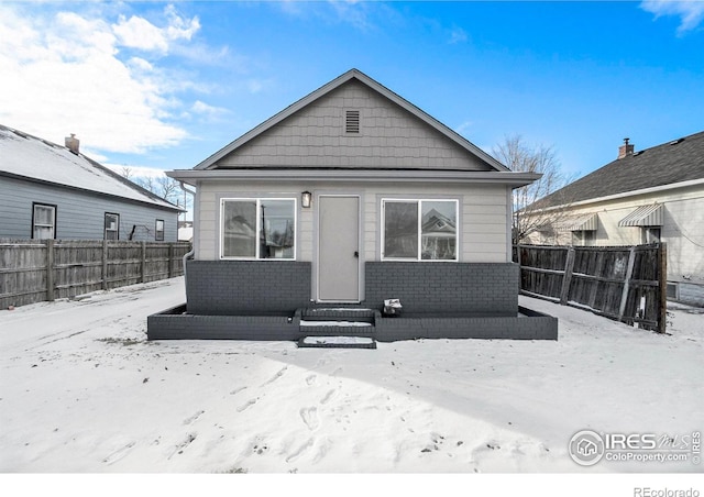 view of snow covered rear of property