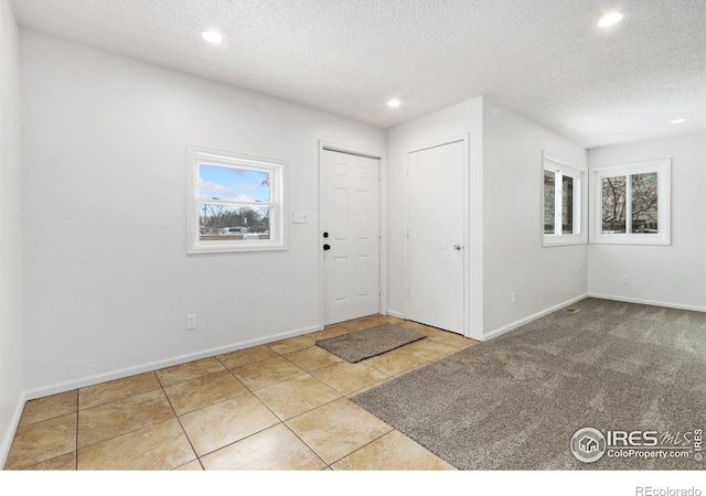 tiled entrance foyer featuring a textured ceiling