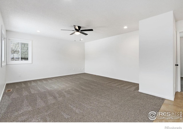 empty room with ceiling fan, a textured ceiling, and carpet flooring