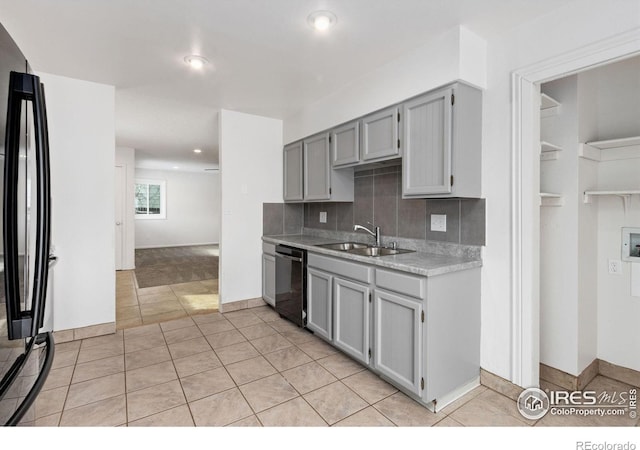 kitchen with tasteful backsplash, sink, dishwashing machine, black fridge, and gray cabinets