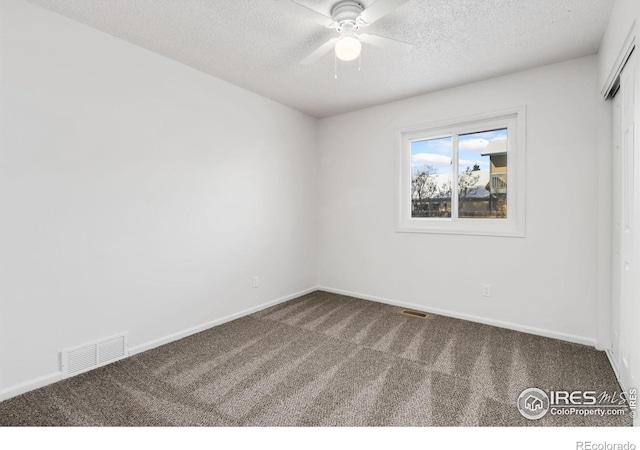 carpeted empty room featuring ceiling fan and a textured ceiling