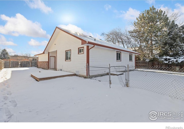 view of snow covered back of property