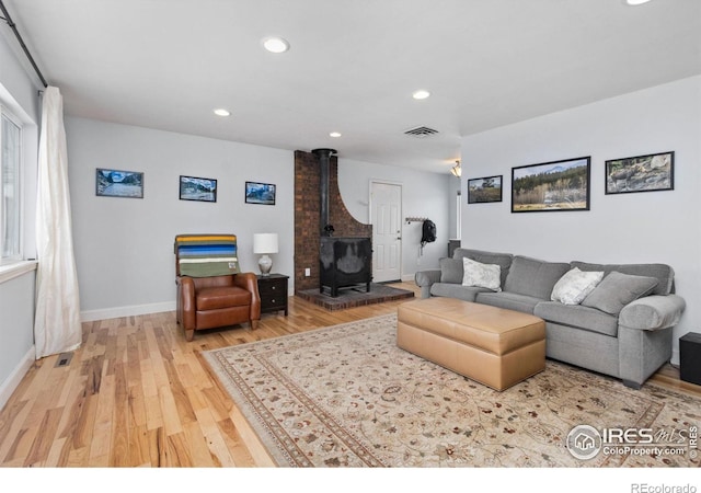 living room featuring wood-type flooring and a wood stove