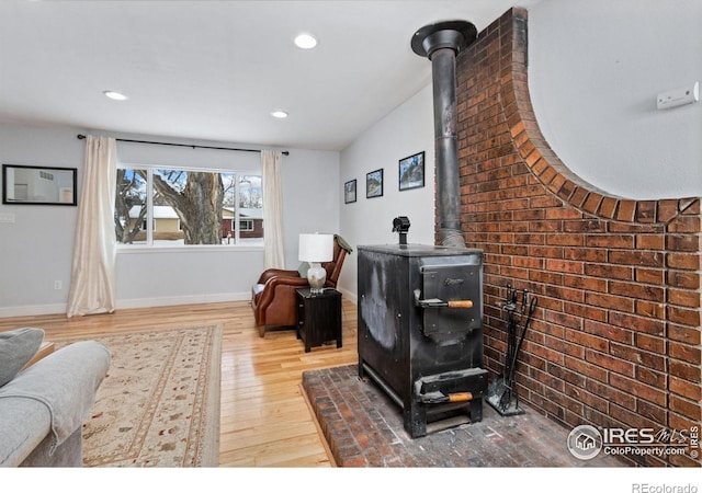 living room featuring a wood stove and hardwood / wood-style flooring