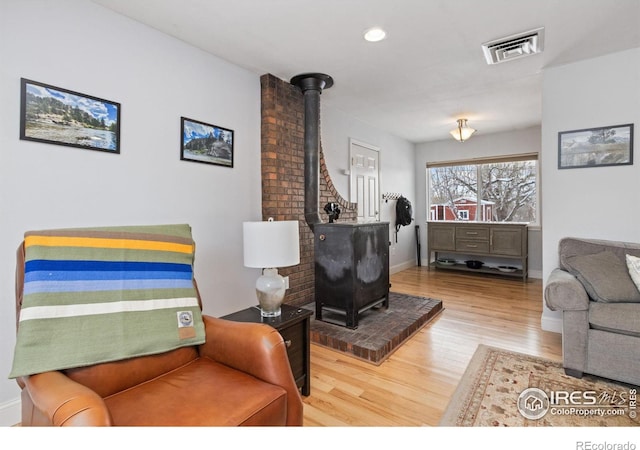 living room featuring a wood stove and hardwood / wood-style floors