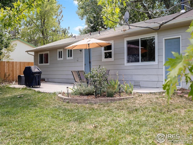 back of property with a lawn and a patio