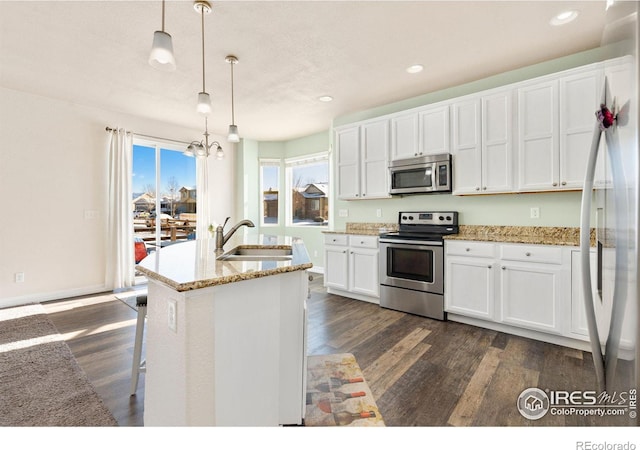 kitchen with sink, pendant lighting, white cabinetry, and appliances with stainless steel finishes