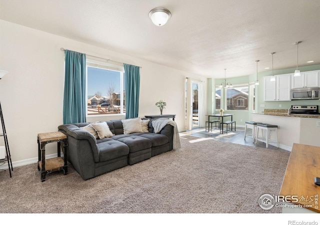 carpeted living room featuring a notable chandelier