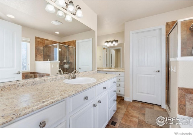 bathroom featuring an enclosed shower and vanity