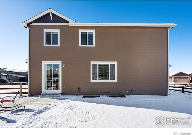 view of snow covered rear of property