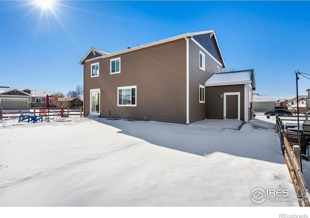 view of snow covered rear of property