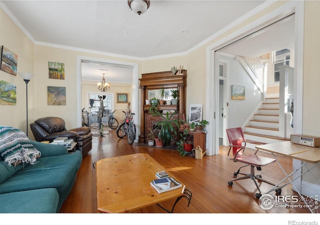 living room featuring hardwood / wood-style flooring, a chandelier, and ornamental molding