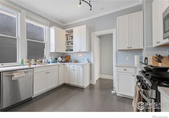 kitchen featuring dark tile patterned flooring, white cabinetry, appliances with stainless steel finishes, and crown molding