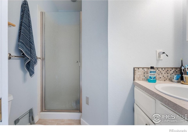 bathroom with toilet, decorative backsplash, an enclosed shower, and vanity