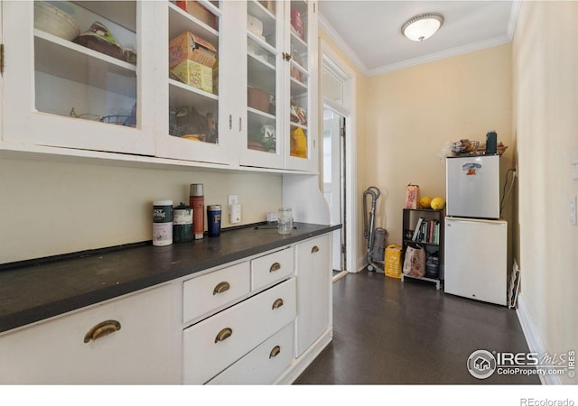 kitchen featuring white cabinetry, white refrigerator, and crown molding