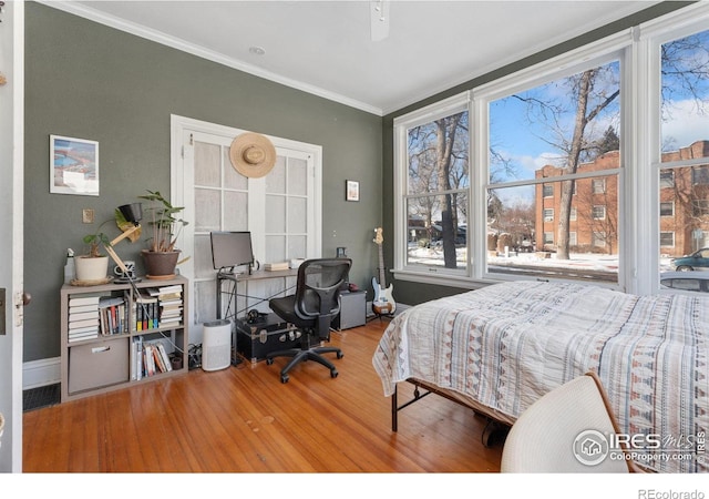 bedroom featuring ceiling fan, crown molding, and wood-type flooring