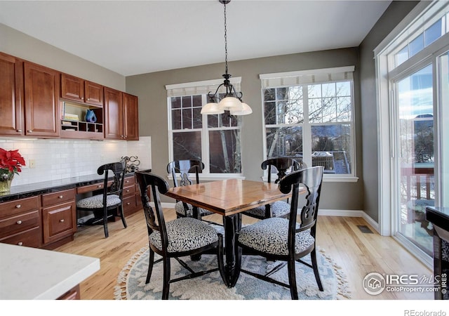 dining room featuring built in desk and light hardwood / wood-style floors