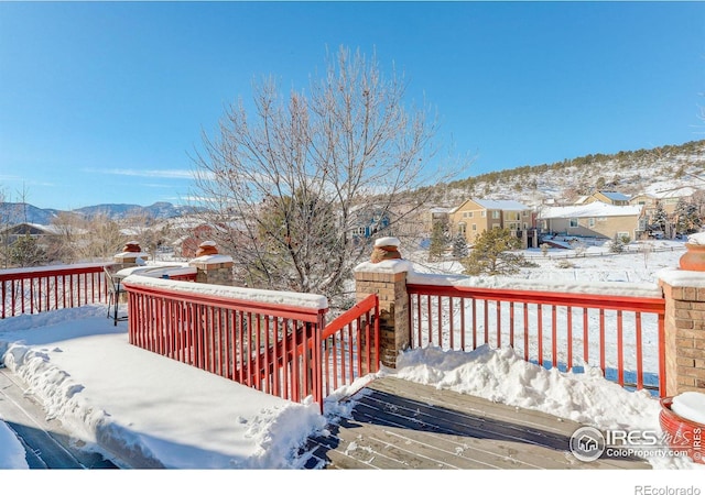 snow covered deck featuring a mountain view