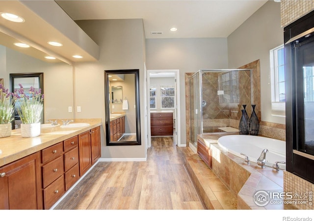 bathroom featuring vanity, a wealth of natural light, independent shower and bath, and hardwood / wood-style floors