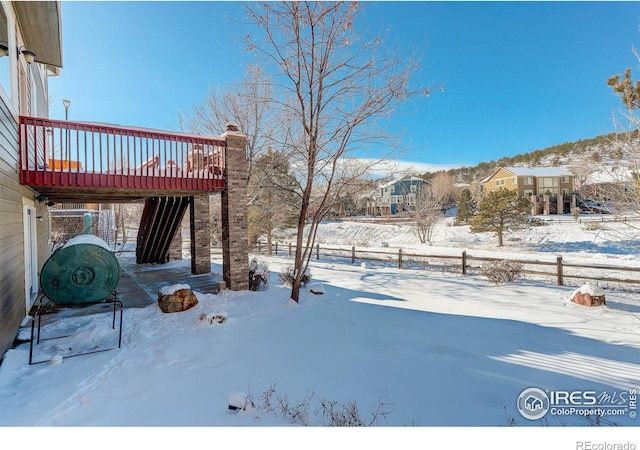 snowy yard with a deck