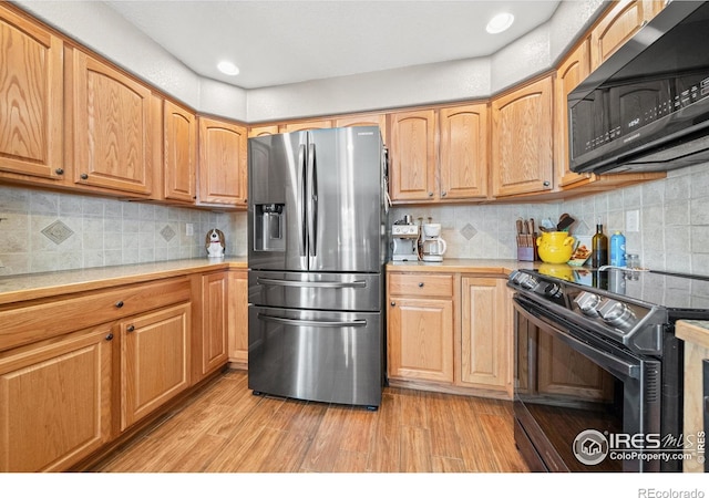 kitchen featuring stainless steel fridge with ice dispenser, light wood-type flooring, range with electric cooktop, and tasteful backsplash