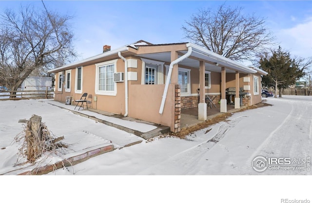 view of snowy exterior featuring covered porch