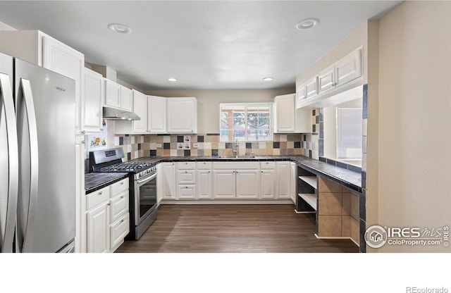 kitchen with white cabinets, dark hardwood / wood-style flooring, stainless steel appliances, tasteful backsplash, and sink