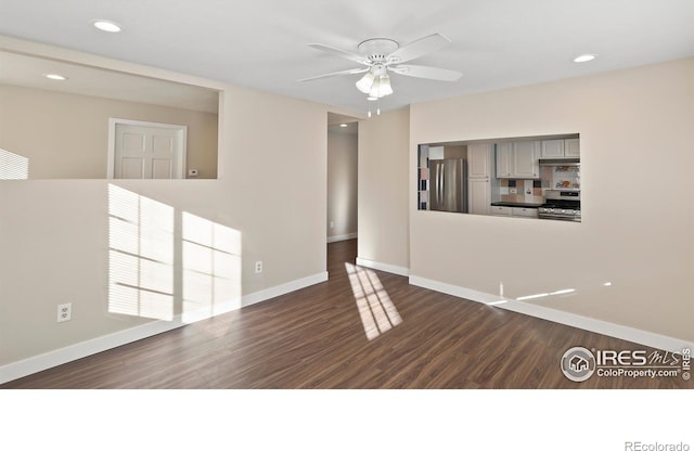 spare room featuring ceiling fan and dark hardwood / wood-style flooring