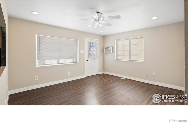 foyer featuring an AC wall unit, dark hardwood / wood-style flooring, and ceiling fan