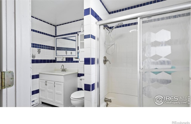 bathroom featuring toilet, tile walls, and vanity