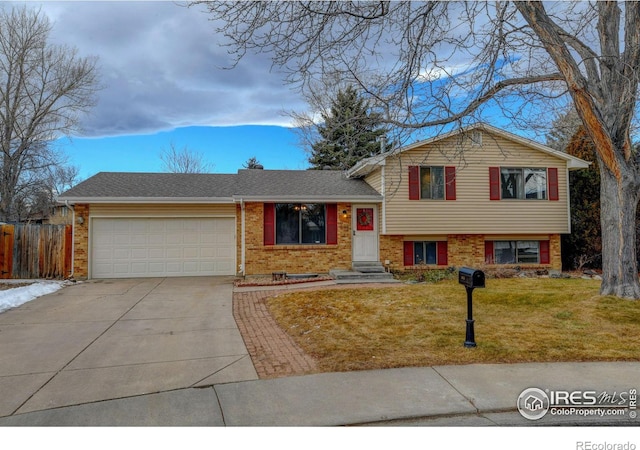 tri-level home featuring a garage and a front lawn